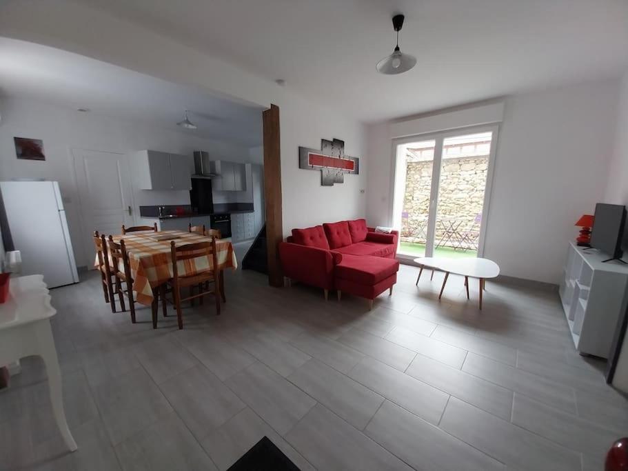 sala de estar con sofá rojo y mesa en Agréable maison 5 couchages, en Prunay-le-Gillon