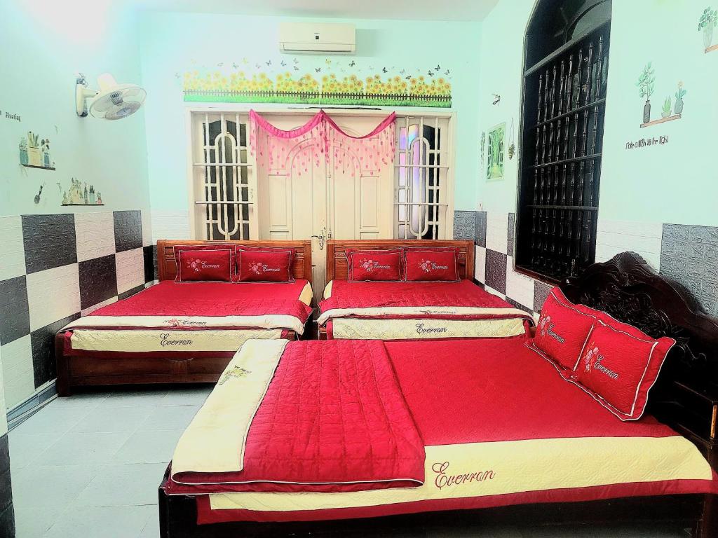 two beds in a room with red sheets at Motel Thành Đạt in Vung Tau