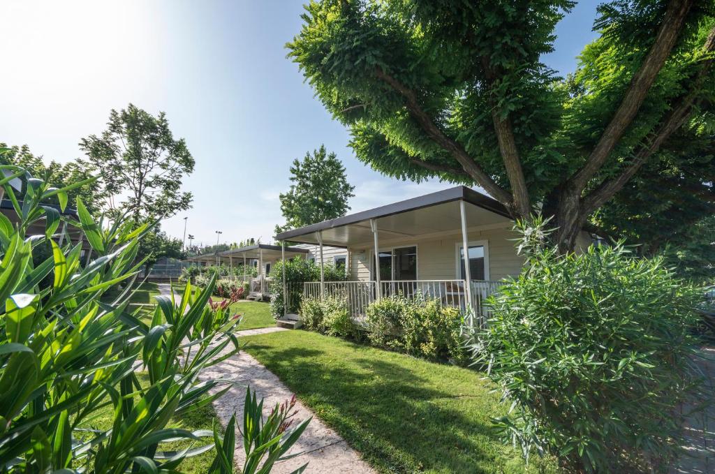 拉齊塞的住宿－奧羅湖濱露營酒店，院子里有树的房子