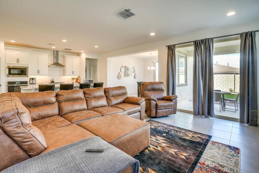 sala de estar con sofá marrón y sillas en Newly Built Glendale Home 5 Mi to Westgate!, en Glendale