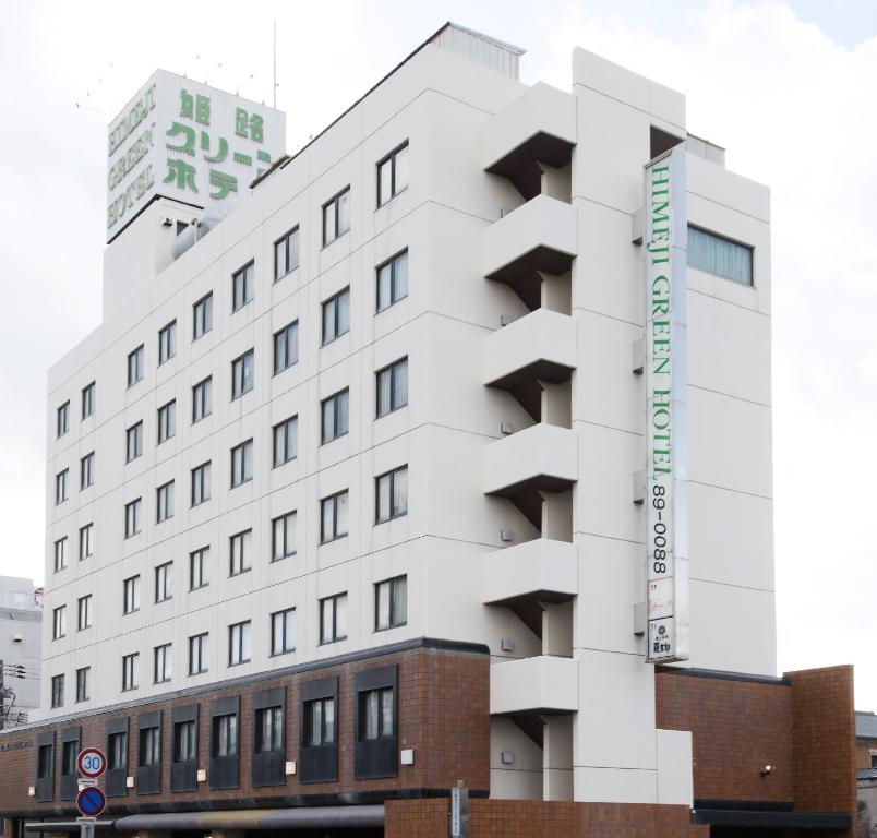 un edificio blanco con un cartel en el costado en Himeji Green Hotel Sakamoto, en Himeji
