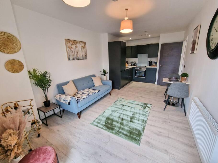 a living room with a blue couch and a kitchen at Liverpool Baltic Flat in Liverpool