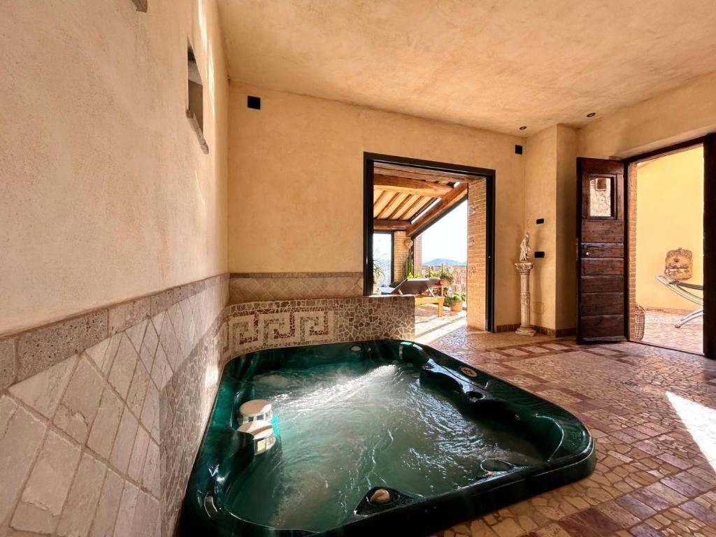 una grande vasca da bagno verde in una stanza di B&B and Wellness Il Pomario di Montepiglio Resort Naturista ad Amelia