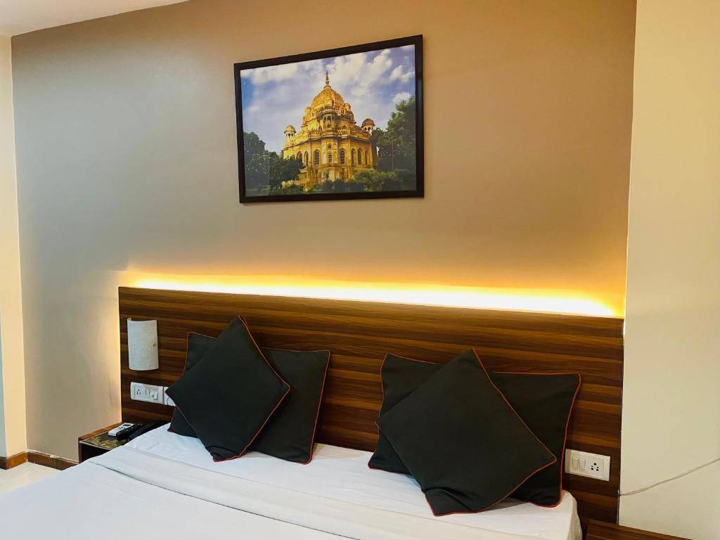 una habitación de hotel con una cama con una foto en la pared en THE ROYAL PRESIDENCY INN en Lucknow