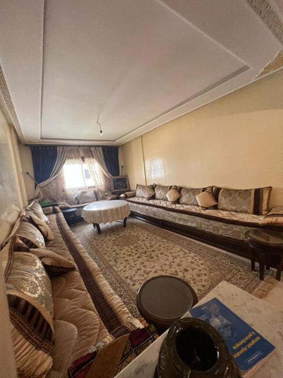 sala de estar con sofá largo y mesa en Appartement 2 Chambres à Malabata en Tánger