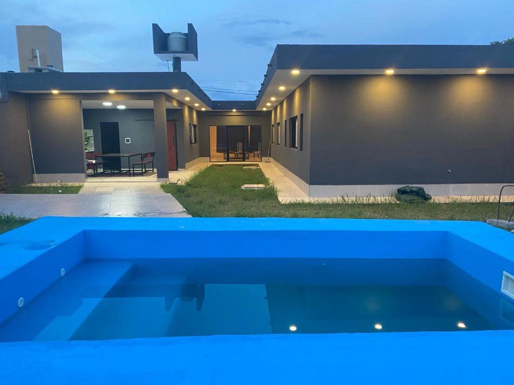 una casa con una piscina azul delante de ella en DESCANSO JUJEÑO, en San Antonio