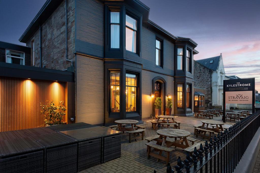 a patio with tables and benches in front of a building at The Kylestrome in Ayr