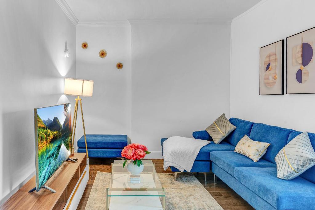 a living room with a blue couch and a tv at Stylish 2Bd in Brooklyn Heights in Brooklyn