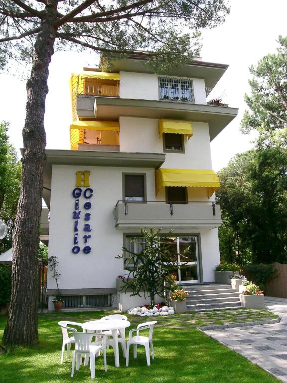 a building with tables and chairs in front of it at Hotel Giulio Cesare in Cinquale