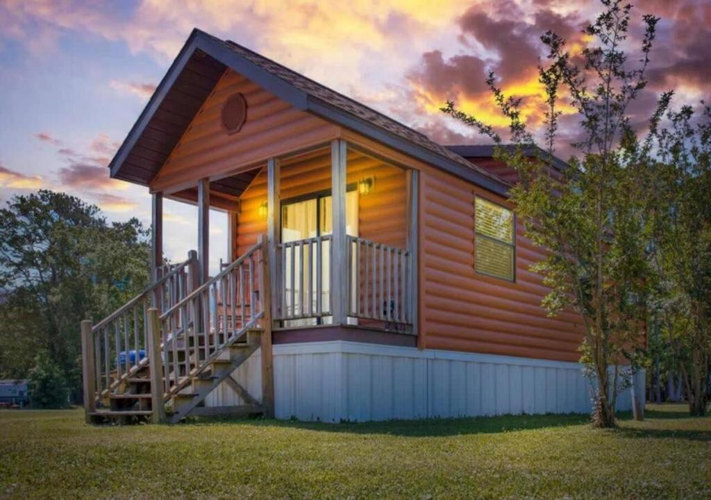 eine Blockhütte mit einer Veranda und einer Terrasse in der Unterkunft Cozy 1BR Cabin in Jacksonville in Jacksonville