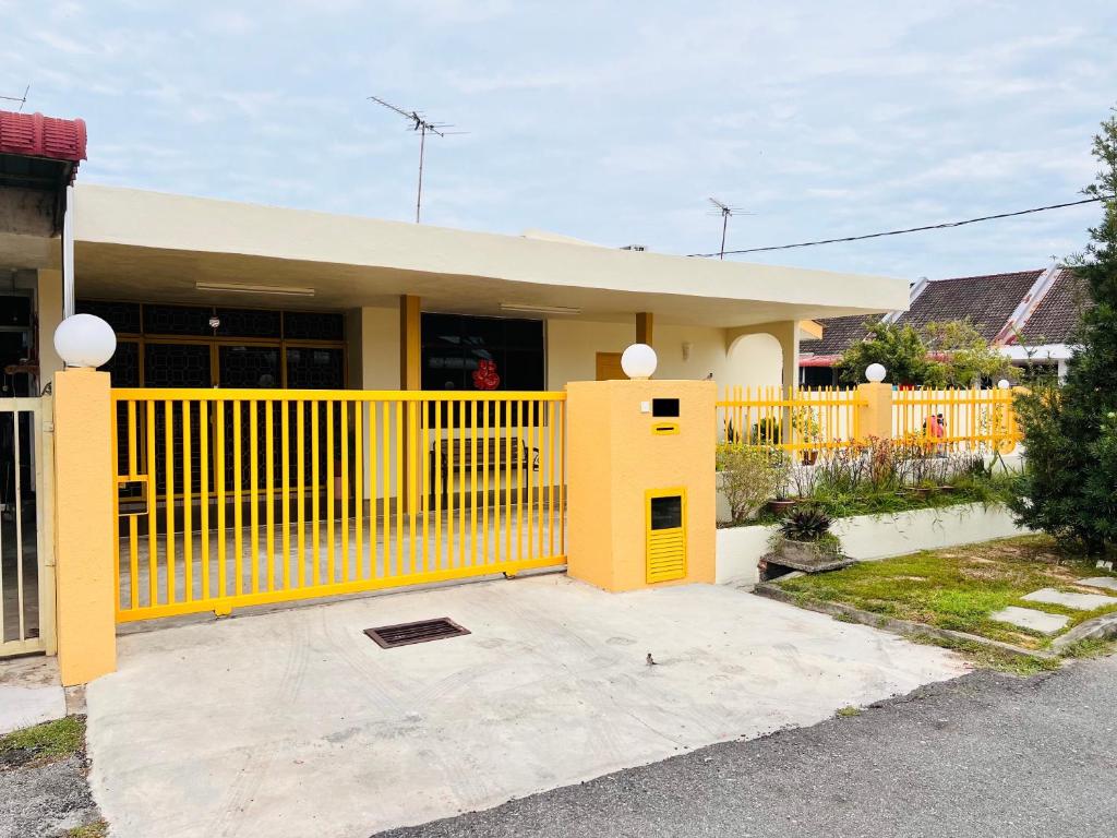 a yellow fence in front of a house at MH Homestay No2 at Alor Setar in Alor Setar