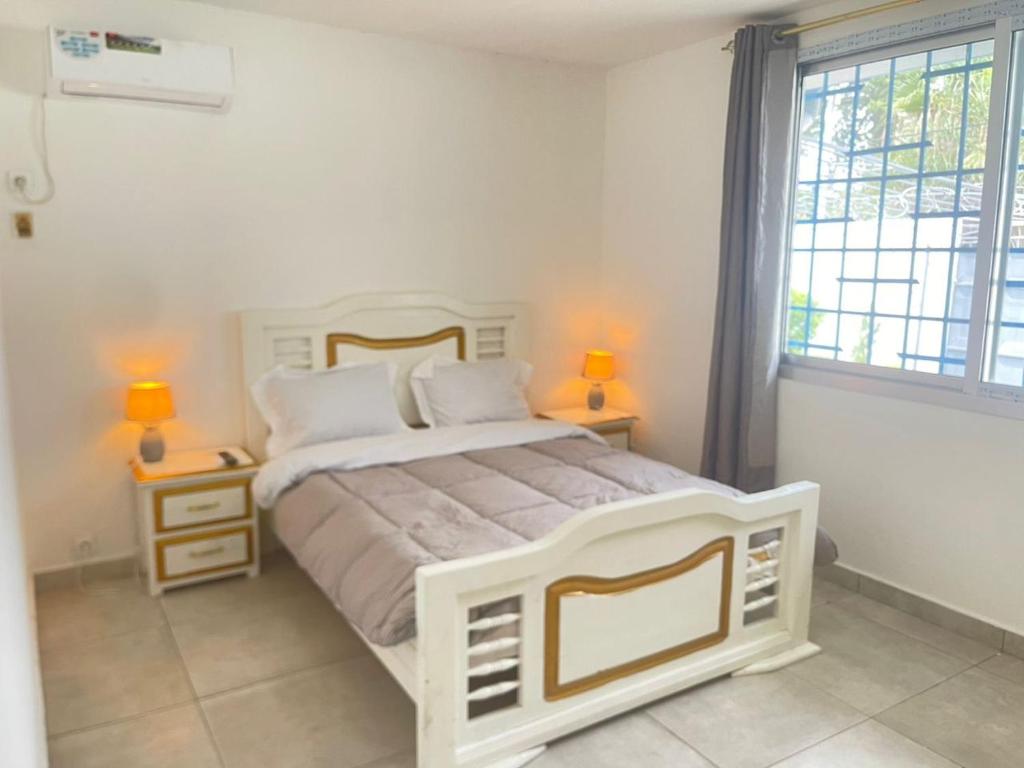 a bedroom with a large white bed with two lamps at louis LBV in Libreville