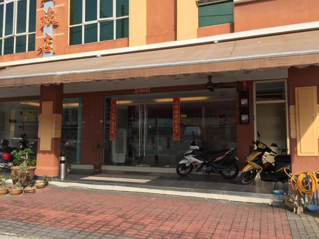 een groep motorfietsen geparkeerd buiten een gebouw bij HP Rooms All Star Hotel in Melaka