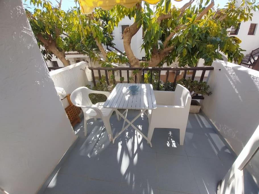 una mesa y sillas en un balcón con árboles en Marino II REA-MA207, en Alcossebre