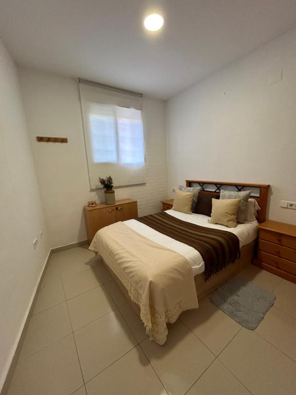 a bedroom with a large bed and a window at Aprt. Con vistas Foro Romano in Cartagena