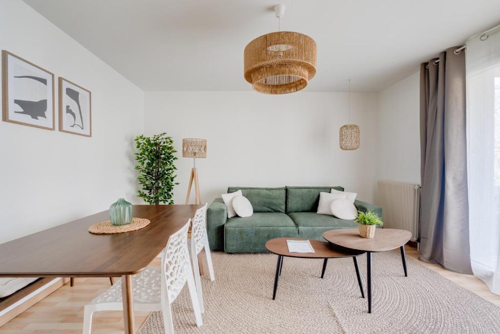 un salon avec un canapé vert et des tables dans l'établissement Élégance, charme et confort, à Toulouse