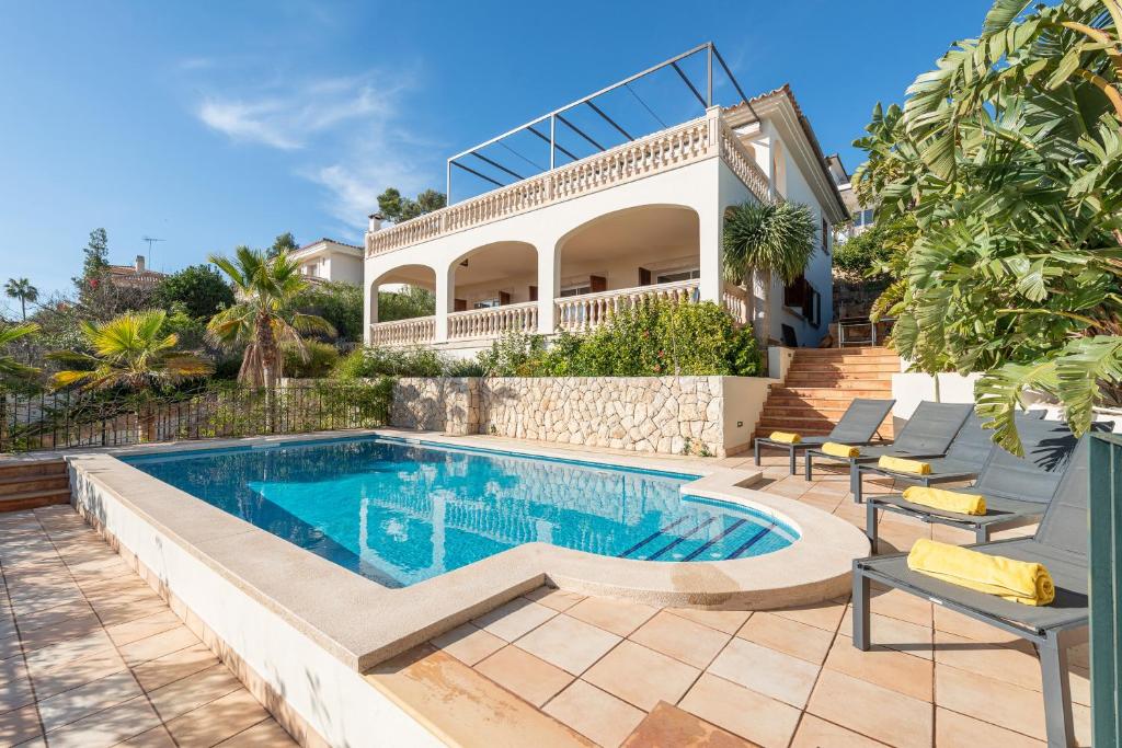 a swimming pool in front of a house at Villa Bendinat 10 in Calvia Town