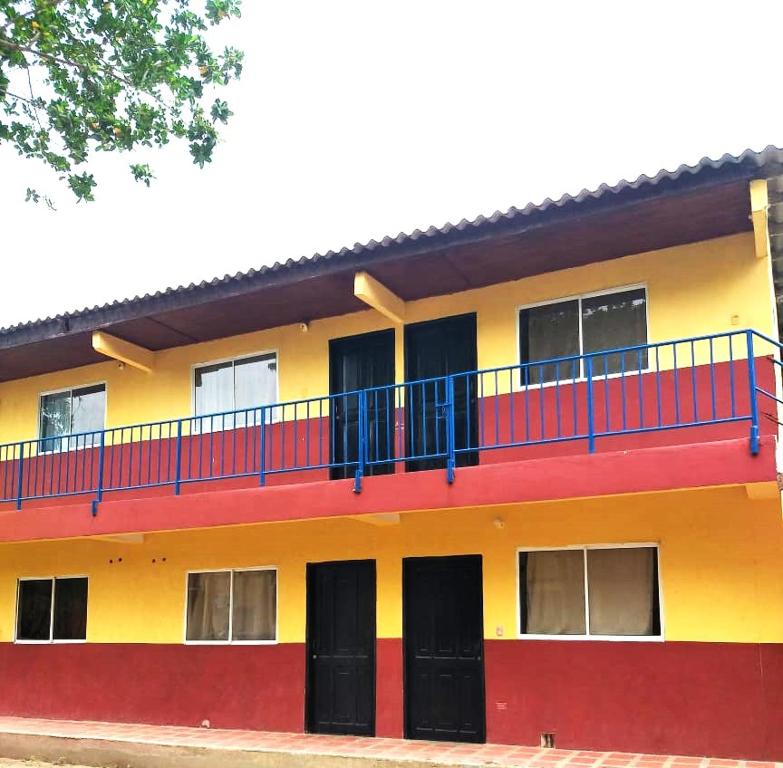 ein rotes gelbes und blaues Gebäude mit einem Balkon in der Unterkunft Apartamentos Coveñas in Coveñas