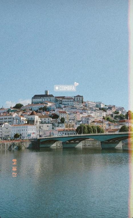 a bridge over a river with a city in the background at Unique Experience in Coimbra