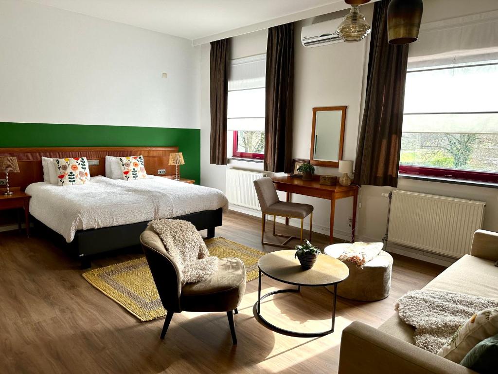 ein Schlafzimmer mit einem Bett und ein Wohnzimmer mit einem Sofa in der Unterkunft Guesthouse De Wissen in Dilsen-Stokkem