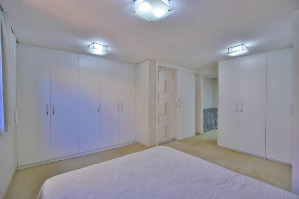 an empty room with white cabinets and a rug at Chalé Lago Norte in Brasilia