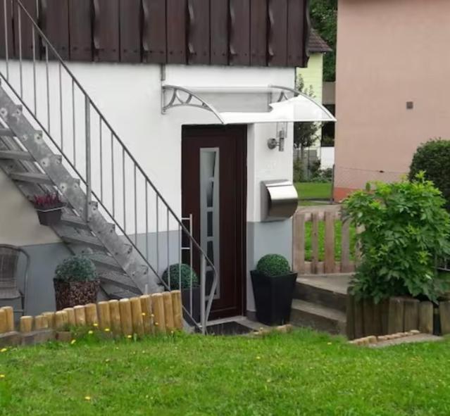 a front door of a house with a stair case at Schöne Ferienwohnung in Lehrberg