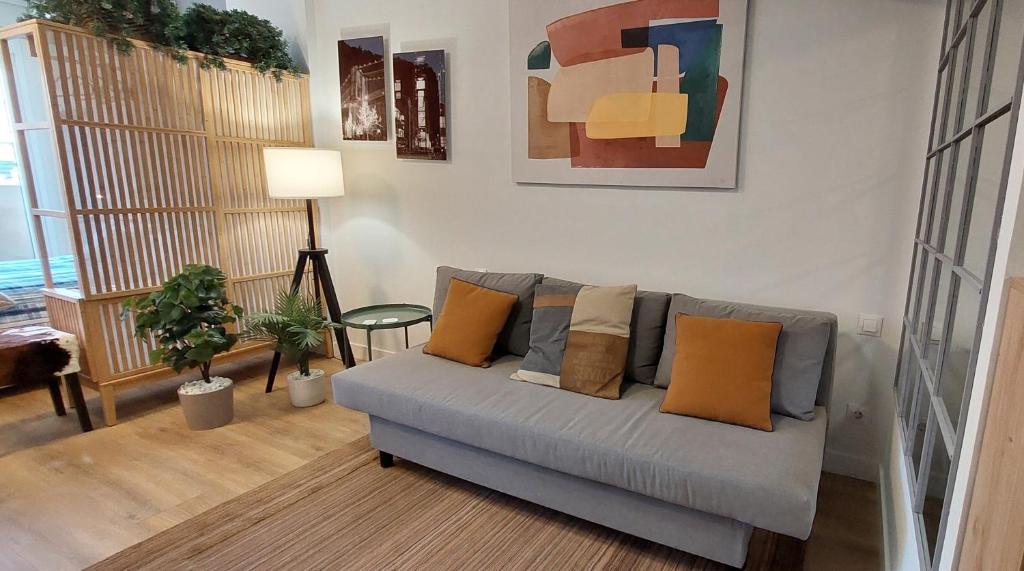 sala de estar con sofá y almohadas en Studio Europa 30, en San Sebastián de los Reyes