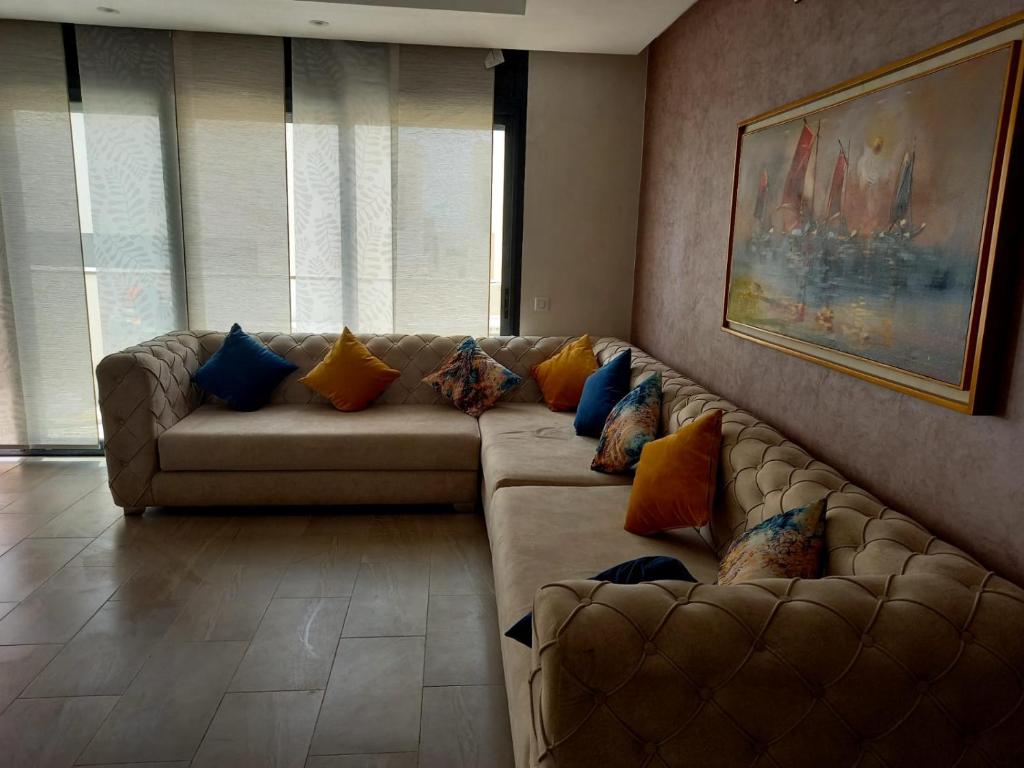 a living room with a couch with pillows on it at Luxe Bord de Mer Appart Prestige in Agadir