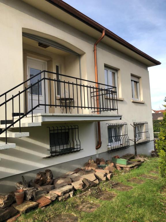 a house with stairs and a balcony and logs at Townhouse - Strasbourg Robertsau in Strasbourg