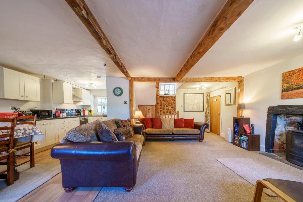 uma sala de estar com dois sofás e uma cozinha em Brock Cottage em Gosforth