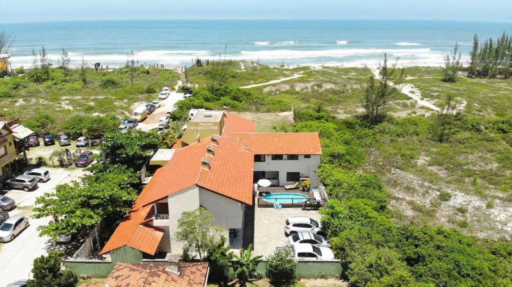 eine Luftansicht eines Hauses und des Ozeans in der Unterkunft Pousada Caminho do Mar MADHOUZE in Garopaba