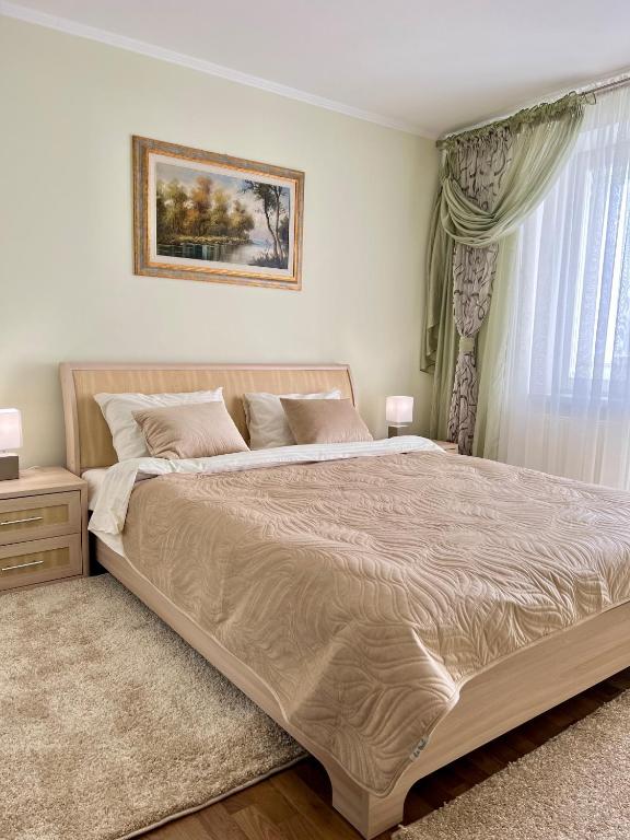 a bedroom with a large bed and a window at Подобово квартира Тернопіль Бам 2 кімнати in Ternopilʼ