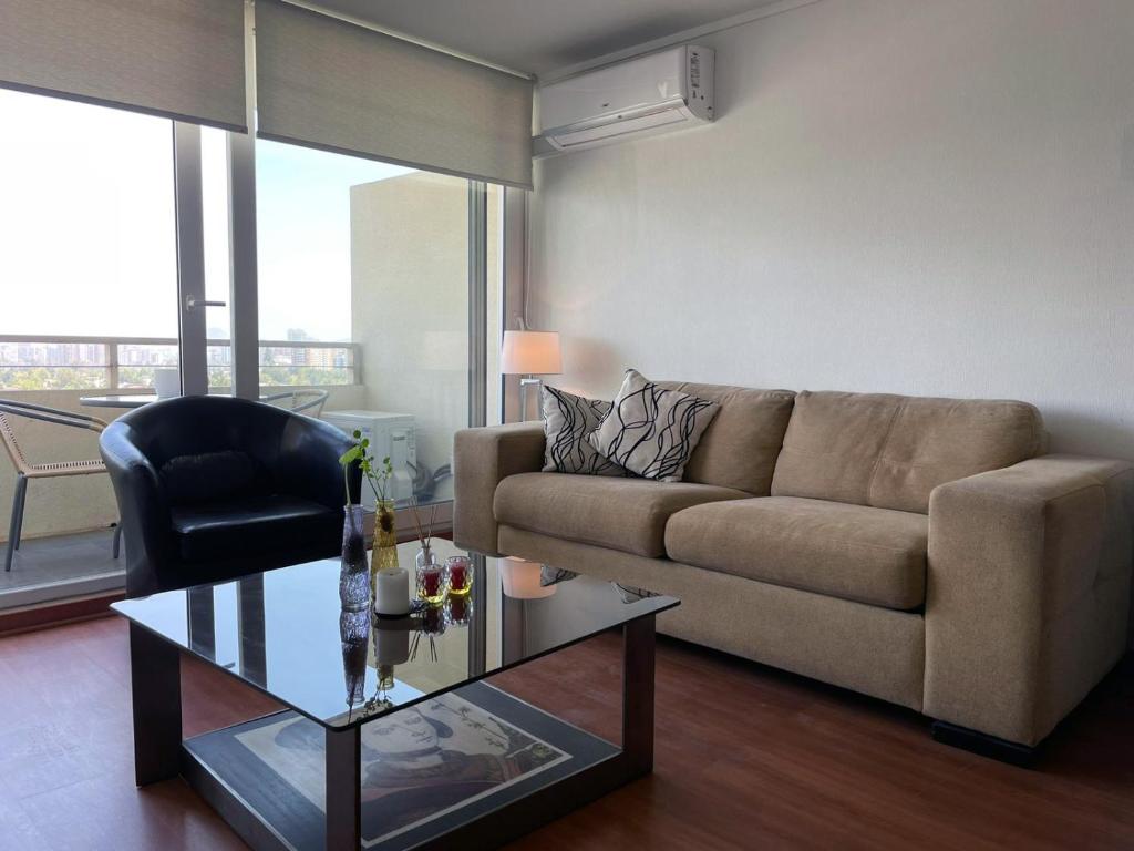 uma sala de estar com um sofá e uma mesa de vidro em Las Condes, Excelentes Apartamentos - Sofia Camilla Propiedades em Santiago