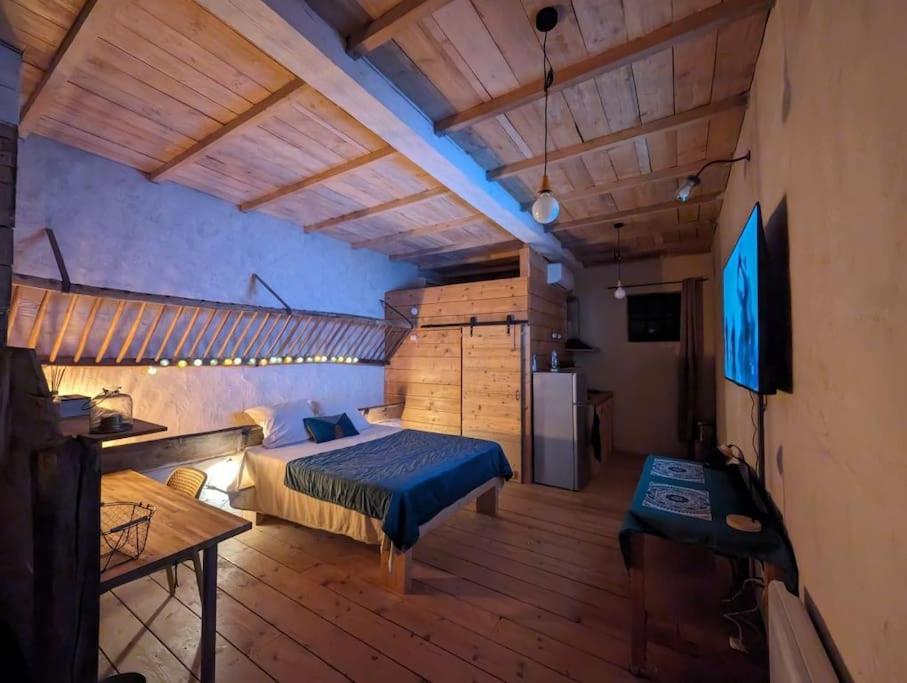 - une chambre avec un lit et un bureau dans l'établissement Logement - Studio indépendant à Pérouges, à Pérouges