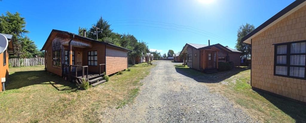 Piruquina的住宿－HelChiloé Cabañas，一条土路,上面有几栋小建筑