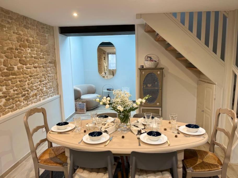 une salle à manger avec une table et des chaises dans l'établissement Coquette maison de pêcheur, à Ouistreham