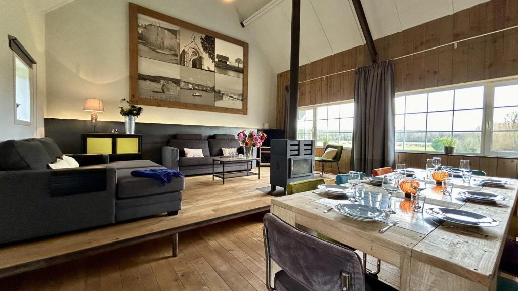 ein Wohnzimmer mit einem Tisch und einem Sofa in der Unterkunft Le 225 villa 8 personnes in Saint-Valery-sur-Somme