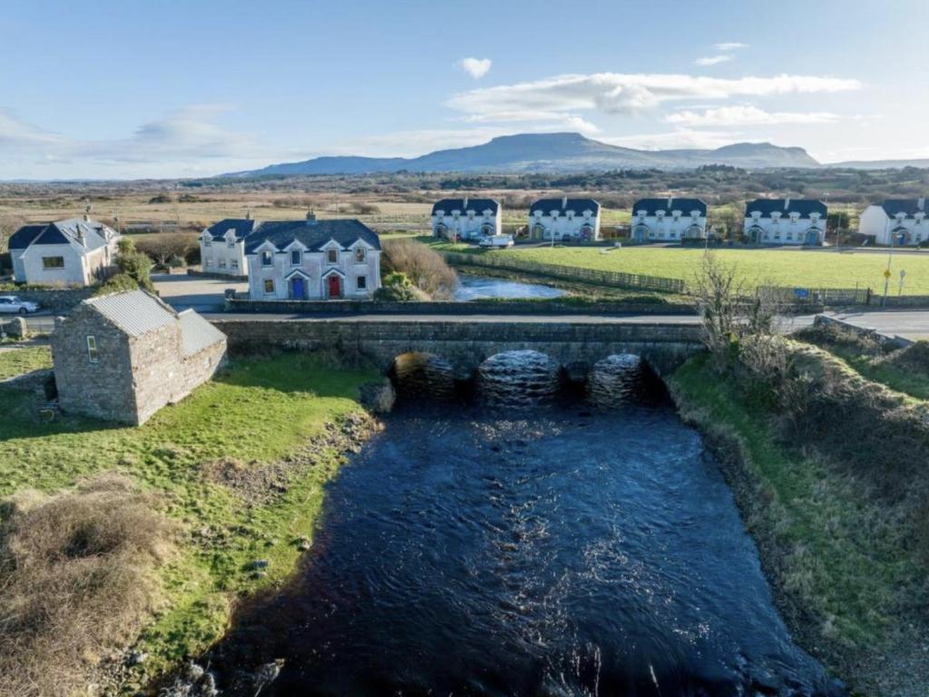 einem Luftblick auf einen Fluss mit einer Brücke in der Unterkunft Fishermans Cottage Stunning Two Bedroom with Views close to town in Bundoran