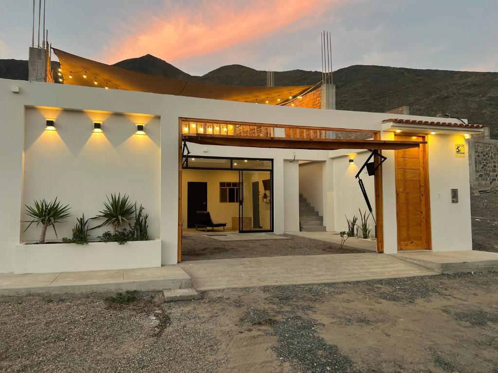 Casa Apartment Playa Tortugas في Tortuga: بيت أبيض صغير مع غروب الشمس في الخلفية