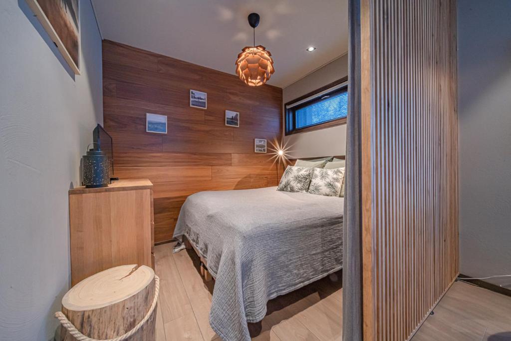 a bedroom with a bed and a wooden wall at Levi Platinum Aurora in Levi