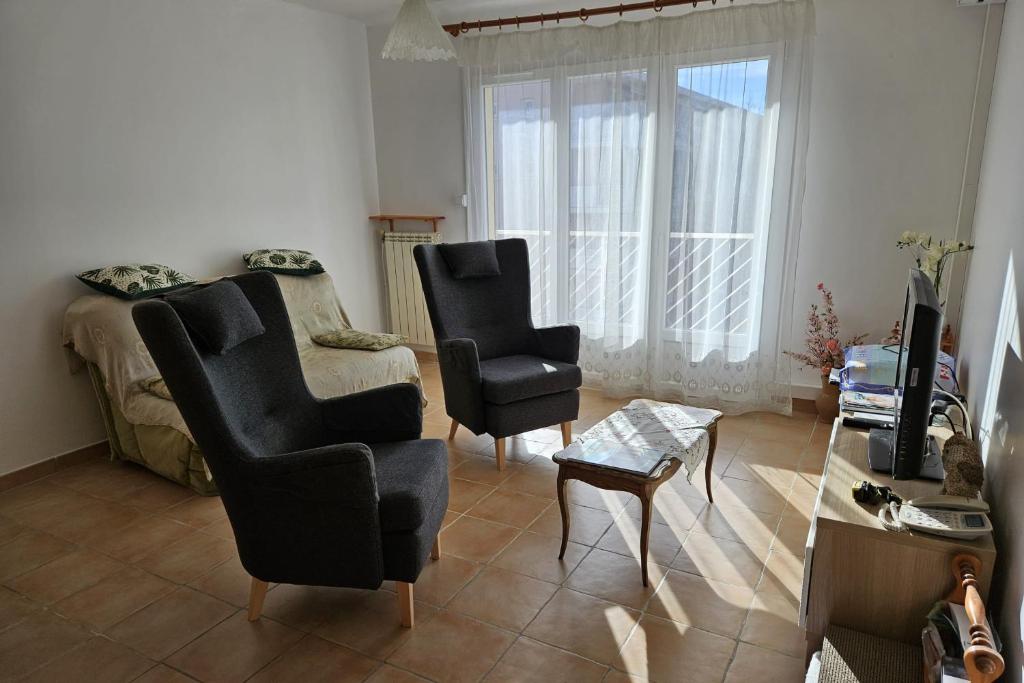 een woonkamer met 2 stoelen en een bank bij Bright apartment - near the beach in Le Pradet