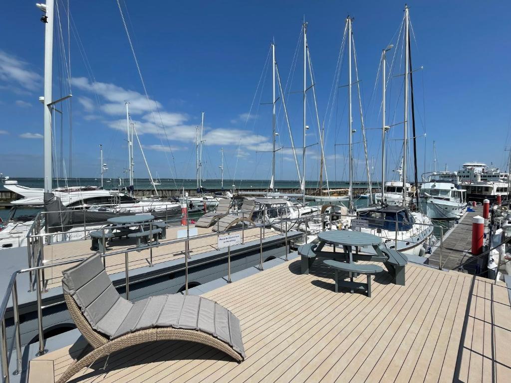a dock with a table and benches and boats at Yarmouth Waterlodge Floating Apartment 1 in Yarmouth