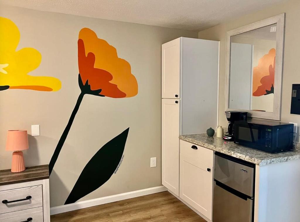 um quarto com uma cozinha com uma flor pintada na parede em Wildflower Room 13 em Townsend
