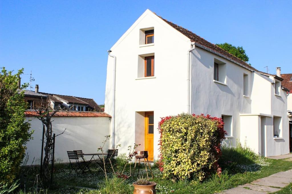 een wit huis met een gele deur bij Holiday home at the edge of La Seine near Giverny in Moisson