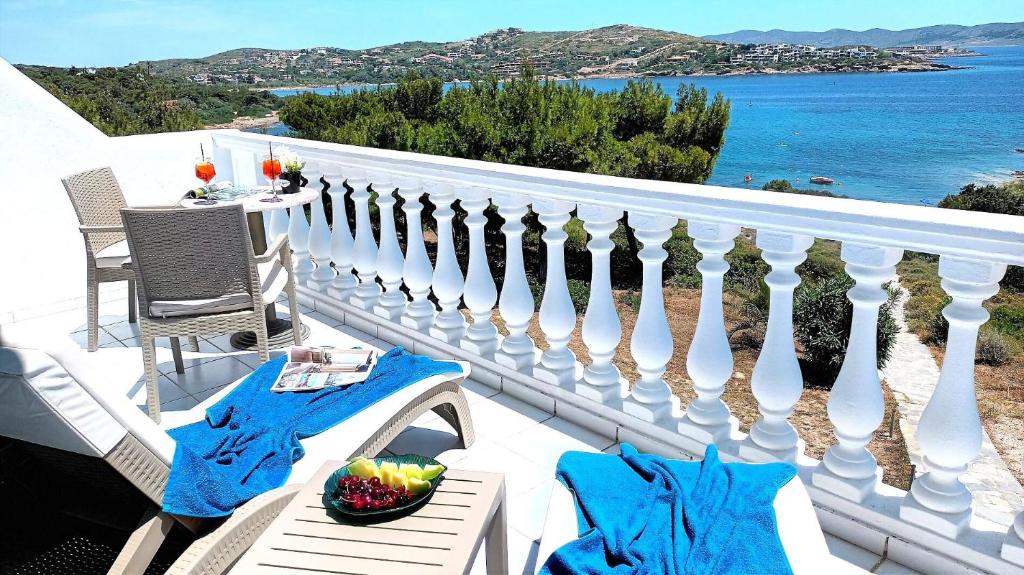 a white balcony with a table and a bowl of fruit at Dea Del Mare complex in front of the sea. in Sounio