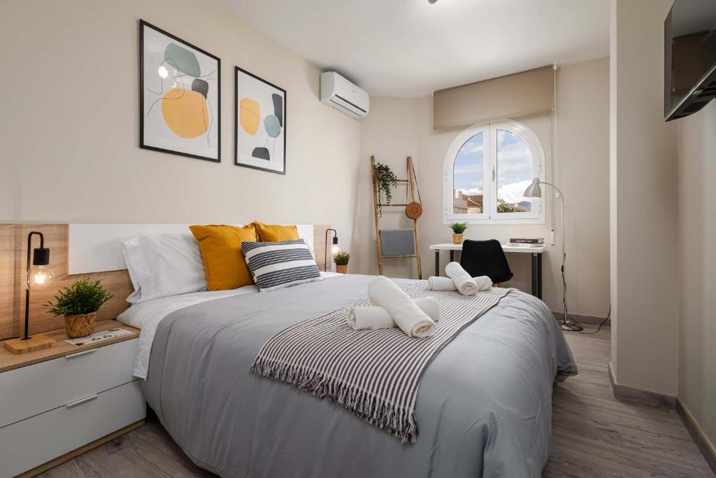 a bedroom with a large bed with two towels at Nordik Rooms Urban - Segalerva "Geiranger" in Málaga