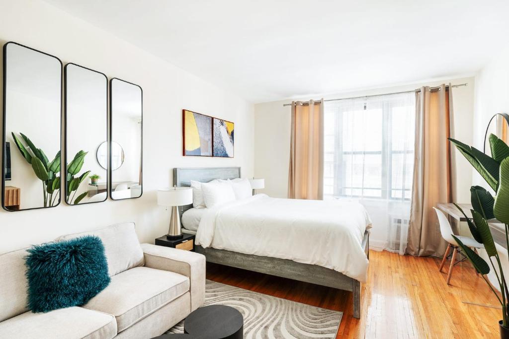 um quarto branco com uma cama e um sofá em 338-3B union square Newly Reno Sleeps 3 em Nova York