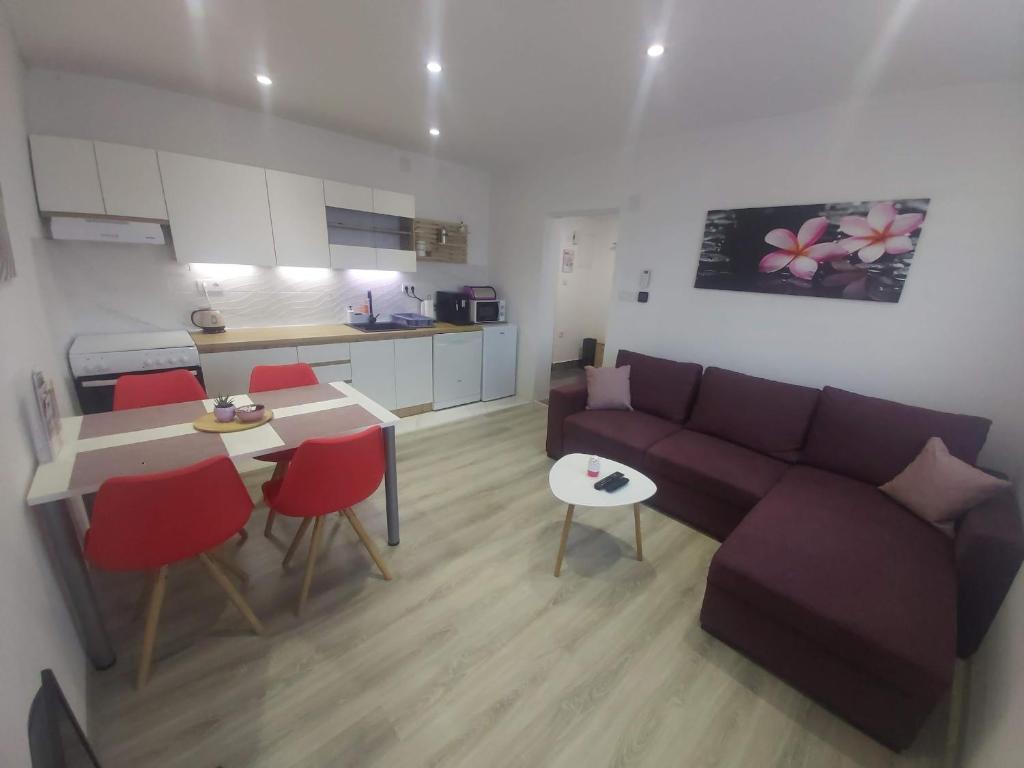 uma sala de estar com um sofá, uma mesa e uma cozinha em Apartman NIKA em Daruvar