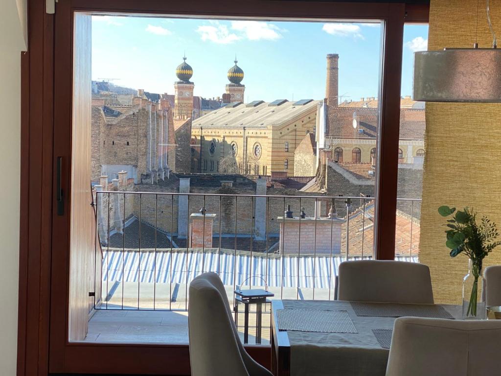 a dining table with a view of a city from a window at PENTHOUSE Synagogue - by Artemisia Luxury Apartments in Budapest
