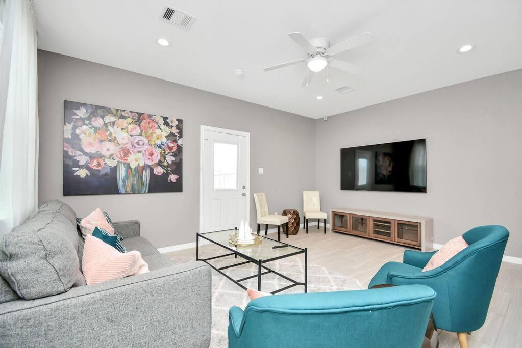 a living room with a couch and chairs and a tv at Rodeo Ready!!!! Modern 3 bedroom home in Houston